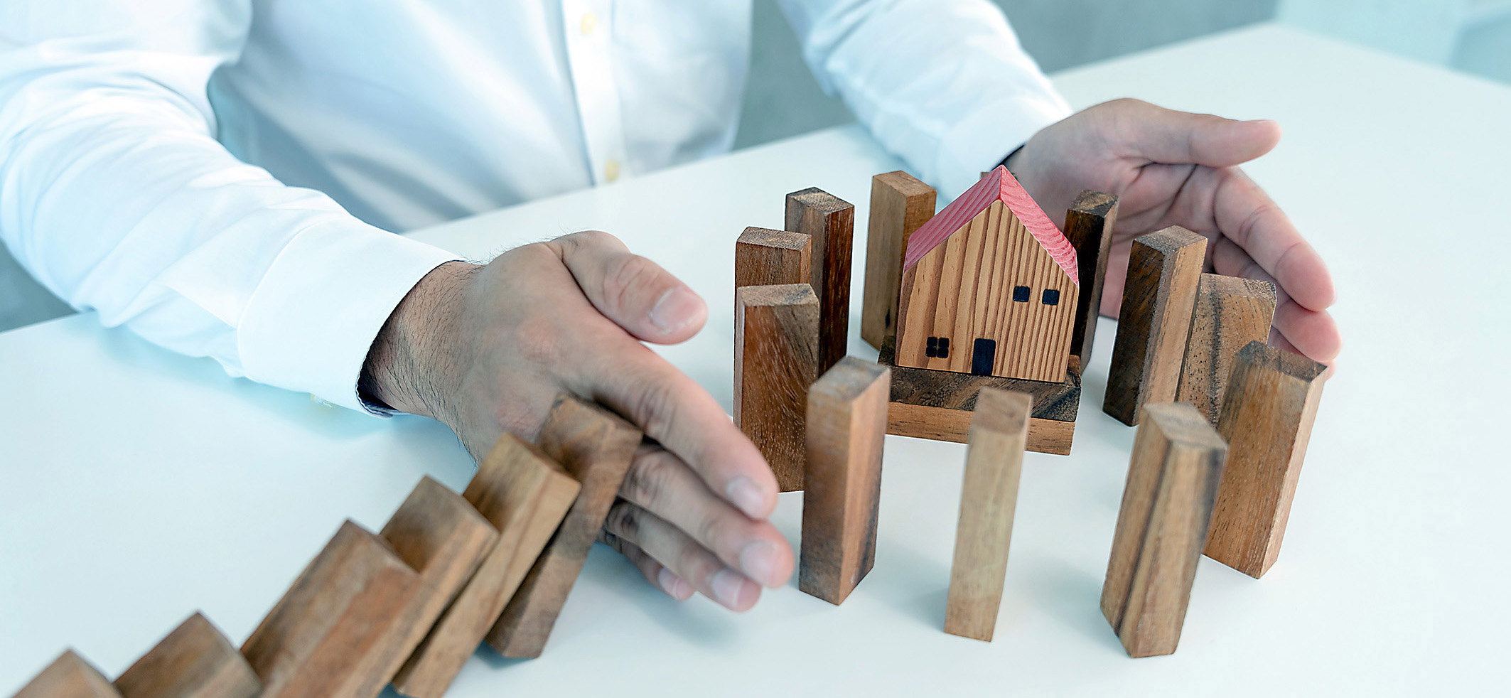 insurance with hands protect domino. Businessman hands stop domi