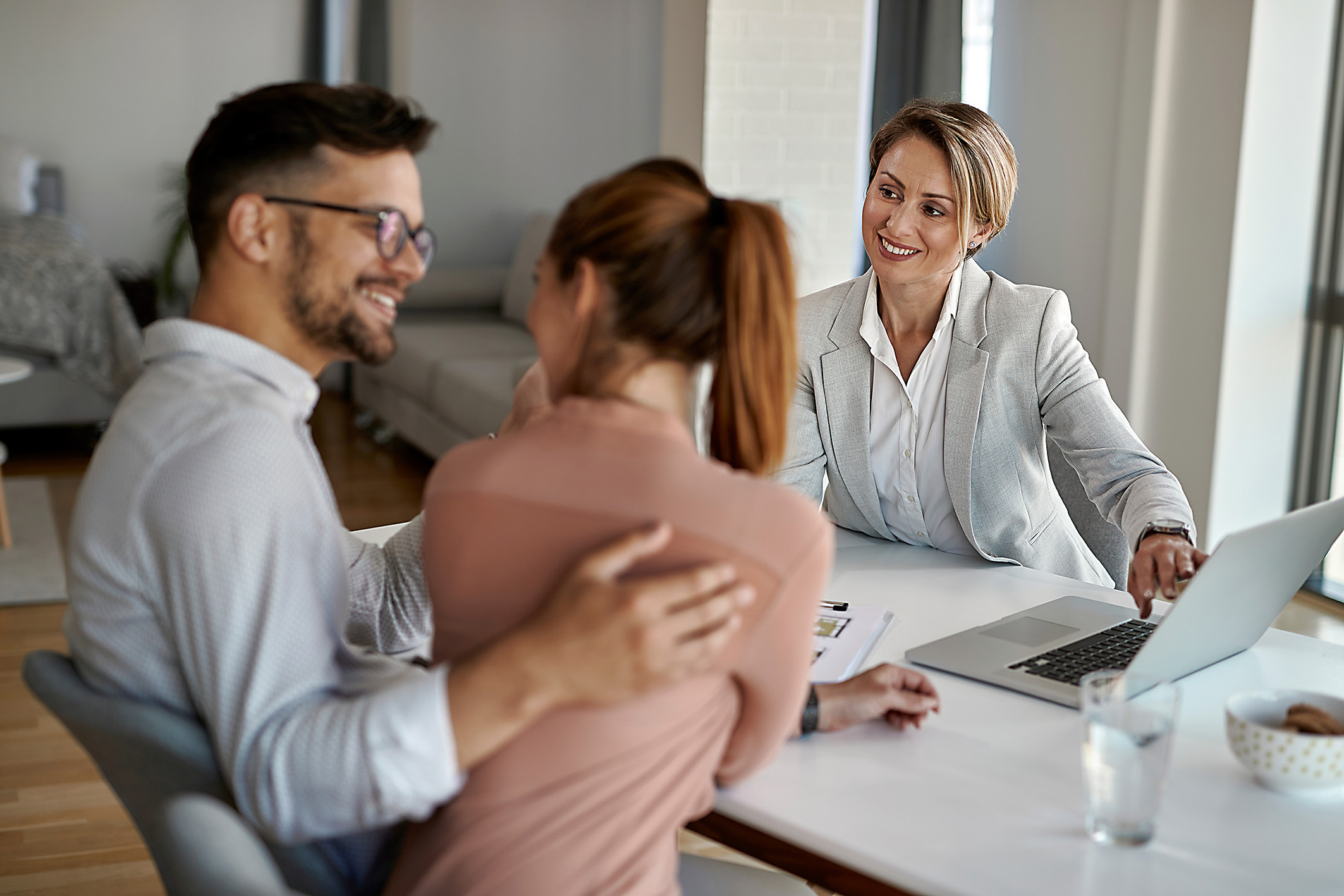 Rear estate agent having meeting with a couple in the office.